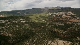 AX130_350 - 5.5K aerial stock footage of flying by low, green mountains, Dixie National Forest, Utah