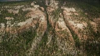 AX130_354E - 5.5K aerial stock footage of flying by narrow gorges in the mountains, Dixie National Forest, Utah