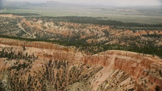 AX130_426 - 5.5K aerial stock footage of passing steep mesa slopes, trees, desert vegetation; Bryce Canyon National Park, Utah