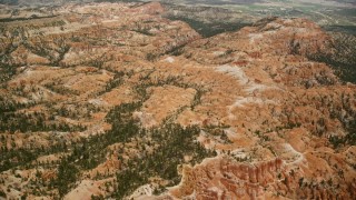 AX130_438E - 5.5K aerial stock footage of hills around a mesa, groups of hoodoos, Bryce Canyon National Park, Utah