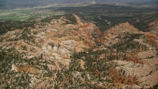 AX130_446E - 5.5K aerial stock footage orbit hills, trees, dirt road winding through canyon at Bryce Canyon National Park, Utah
