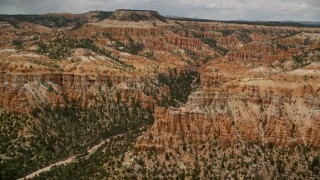 AX130_450 - 5.5K stock footage aerial video of a view of hoodoos, buttes, canyon, mesa in the background, Bryce Canyon National Park, Utah