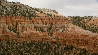 AX130_472 - 5.5K aerial stock footage of passing by group of hoodoos beside a mesa, Bryce Canyon National Park, Utah