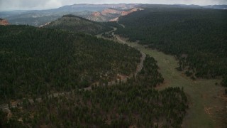 AX131_008E - 5.5K aerial stock footage of flying over Highway 63, forest, approach Bryce Canyon National Park, Utah