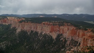 AX131_021E - 5.5K aerial stock footage of passing by rock formations, Pink Cliffs, trees, Bryce Canyon National Park, Utah