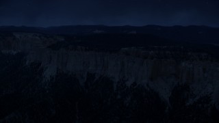 AX131_021_DFN - Aerial stock footage of 4K day for night color corrected aerial footage of flying by rock formations, Pink Cliffs, trees, Bryce Canyon National Park, Utah