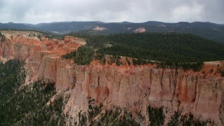 AX131_022 - 5.5K aerial stock footage of passing by rock formations, Pink Cliffs, trees, Bryce Canyon National Park, Utah
