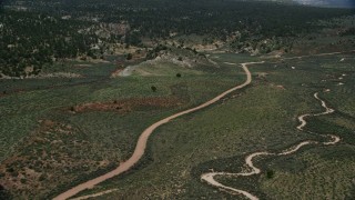 AX131_042 - 5.5K aerial stock footage fly over dirt roads near forest, Grand Staircase-Escalante National Monument, Utah