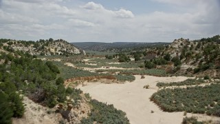 AX131_062E - 5.5K aerial stock footage of flying over the edge of dry riverbed, Grand Staircase-Escalante National Monument, Utah