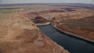 AX131_150E - 5.5K aerial stock footage approach and tilt to Glen Canyon Dam, Glen Canyon Dam Bridge, Arizona