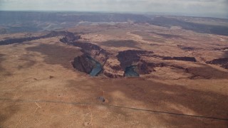 AX131_174E - 5.5K aerial stock footage of flying to the edge of Horseshoe Bend, tilt to Colorado River, Glen Canyon, Arizona