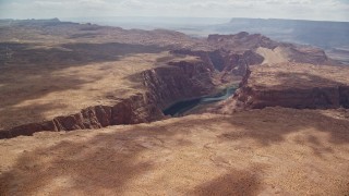 AX131_183E - 5.5K aerial stock footage of approaching bend in the canyon, tilt to Colorado River, Glen Canyon, Arizona