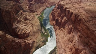 AX131_189E - 5.5K aerial stock footage bird's eye view of the Colorado River at the base of rugged cliffs, Glen Canyon, Arizona