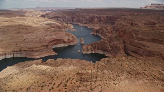 AX131_228E - 5.5K aerial stock footage of approaching and flying over Lake Powell, cliffs, rock formations, Navajo Canyon, Arizona