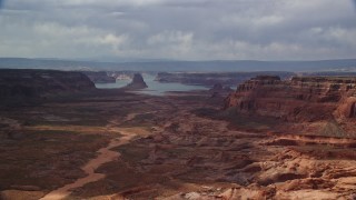 AX132_008 - 5.5K aerial stock footage of flying by buttes, Lake Powell in the distance, Navajo Nation Reservation, Arizona