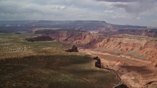 AX132_017E - 5.5K aerial stock footage of a wide canyon between mesas, Navajo Nation Reservation, Utah
