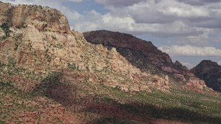 AX132_073E - 5.5K aerial stock footage of flying by a mountain peak with rocky slopes, Navajo Mountain, Utah