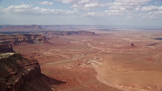 AX132_095E - 5.5K aerial stock footage of of buttes and a wide desert valley, Navajo Nation Reservation, Arizona, Utah