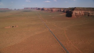 AX132_128 - 5.5K aerial stock footage tilt up Oljeto Road, revealing Oljeto Mesa, Navajo Nation Reservation, Arizona, Utah