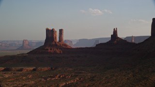 AX133_014 - 5.5K aerial stock footage of flying by buttes, desert valley, Monument Valley, Utah, Arizona, sunset