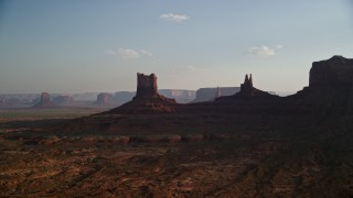 AX133_015E - 5.5K aerial stock footage of desert buttes in Monument Valley, Utah, Arizona, sunset