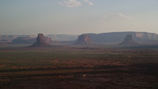 AX133_017E - 5.5K aerial stock footage of a wide view of buttes, mesas across desert valley, Monument Valley, Utah, Arizona, twilight