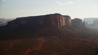 AX133_033 - 5.5K aerial stock footage of a view of Spearhead Mesa in desert valley, Monument Valley, Utah, Arizona, twilight