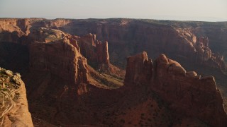 AX133_053E - 5.5K aerial stock footage of flying by Hunt's Mesa and rock formations, Monument Valley, Utah, Arizona, sunset