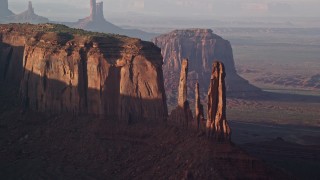 AX133_069E - 5.5K aerial stock footage of flying by Three Sisters and Mitchell Mesa, Monument Valley, Utah, Arizona, twilight