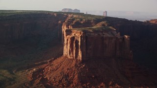 AX133_071E - 5.5K aerial stock footage of flying by Mitchell Mesa in Monument Valley, Utah, Arizona, twilight