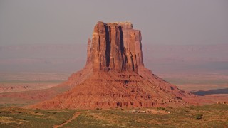 AX133_084E - 5.5K aerial stock footage of flying by East and West Mitten Buttes, Monument Valley, Utah, Arizona, twilight