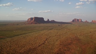 AX133_086E - 5.5K aerial stock footage of flying over highway, approaching buttes in Monument Valley, Utah, Arizona, twilight