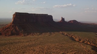AX133_088 - 5.5K aerial stock footage of flying by Eagle Mesa and Setting Hen Butte, Monument Valley, Utah, Arizona, twilight