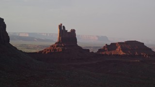 AX133_089E - 5.5K aerial stock footage of passing by Setting Hen Butte in Monument Valley, Utah, Arizona, twilight