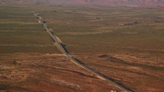 AX133_099 - 5.5K aerial stock footage of passing by Highway 163 in Monument Valley, Utah, Arizona, twilight
