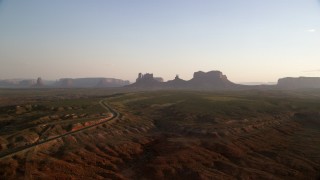 AX133_114 - 5.5K stock footage aerial video of highway to mesas and buttes, Monument Valley, Utah, Arizona, twilight