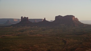 AX133_118E - 5.5K aerial stock footage of a wide view of buttes and highway in Monument Valley, Utah, Arizona, twilight