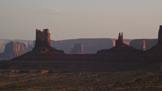 AX133_121E - 5.5K aerial stock footage of buttes on a hazy day, Monument Valley, Utah, Arizona, twilight