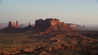 AX133_123E - 5.5K aerial stock footage of passing Brighams Tomb Butte, Monument Valley, Utah, Arizona, twilight