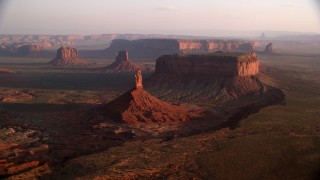 AX133_132 - 5.5K stock footage aerial video of flying by Big Indian Butte, nearby buttes, Monument Valley, Utah, Arizona, twilight