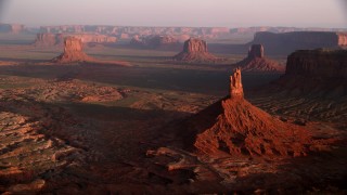 AX133_133 - 5.5K stock footage aerial video approach Big Indian Butte, view of nearby buttes, Monument Valley, Utah, Arizona, twilight