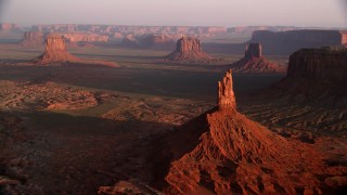 AX133_134 - 5.5K stock footage aerial video fly toward Big Indian Butte, nearby buttes, Monument Valley, Utah, Arizona, twilight
