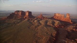AX133_138E - 5.5K aerial stock footage of approaching buttes with valley in background, Monument Valley, Utah, Arizona, twilight