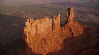 AX133_143 - 5.5K aerial stock footage of flying away from buttes in Monument Valley, Utah, Arizona, sunset