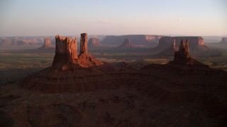 AX133_147 - 5.5K stock footage aerial video of flying toward buttes in famous Monument Valley, Utah, Arizona, sunset