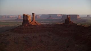 AX133_147E - 5.5K aerial stock footage of flying by buttes with more in the distance, Monument Valley, Utah, Arizona, sunset