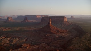 AX133_152E - 5.5K aerial stock footage of passing by buttes and mesas in famous Monument Valley, Utah, Arizona, sunset