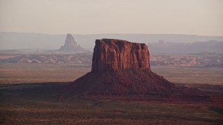 AX133_158E - 5.5K aerial stock footage of flying by Mitchell Butte, Monument Valley, Utah, Arizona, sunset