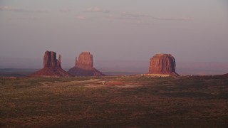 AX133_169E - 5.5K aerial stock footage of flying by buttes and The View Hotel in famous Monument Valley, Utah, Arizona, sunset