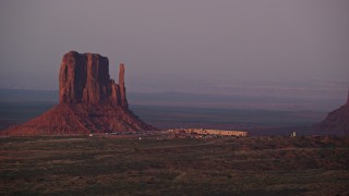 AX133_172 - 5.5K aerial stock footage of lying by Mitten Butte and The View Hotel, Monument Valley, Utah, Arizona, sunset